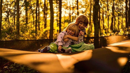Two children enjoying a Multi-Person Hammock Three Point Design Portable Hammock Multi-functional Triangle Aerial Mat in the woods.