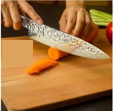 Kitchen Knife Professional Japanese Chef Knives cutting a carrot on a wooden chopping board.